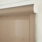 Beige sunscreen roller blind with matching valance.