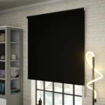 Black blackout roller blind on a white brick wall.