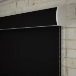 Close-up of a black roller blind headrail and chain