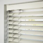 Close-up of off-white blind slats and matching headrail.