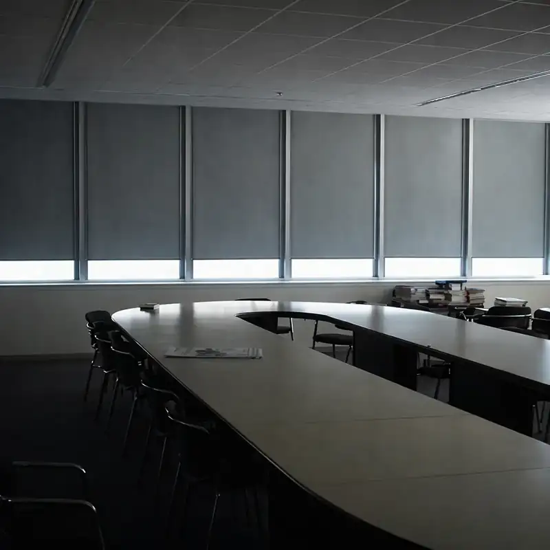 Commercial grey roller blinds in a large conference room.