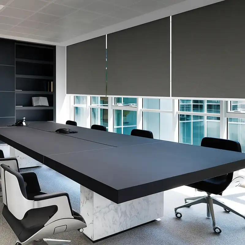 Dark grey roller blinds in a minimalist executive boardroom.