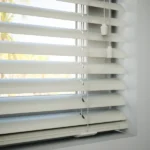 Detail of off-white slats and bottom rail with cord.