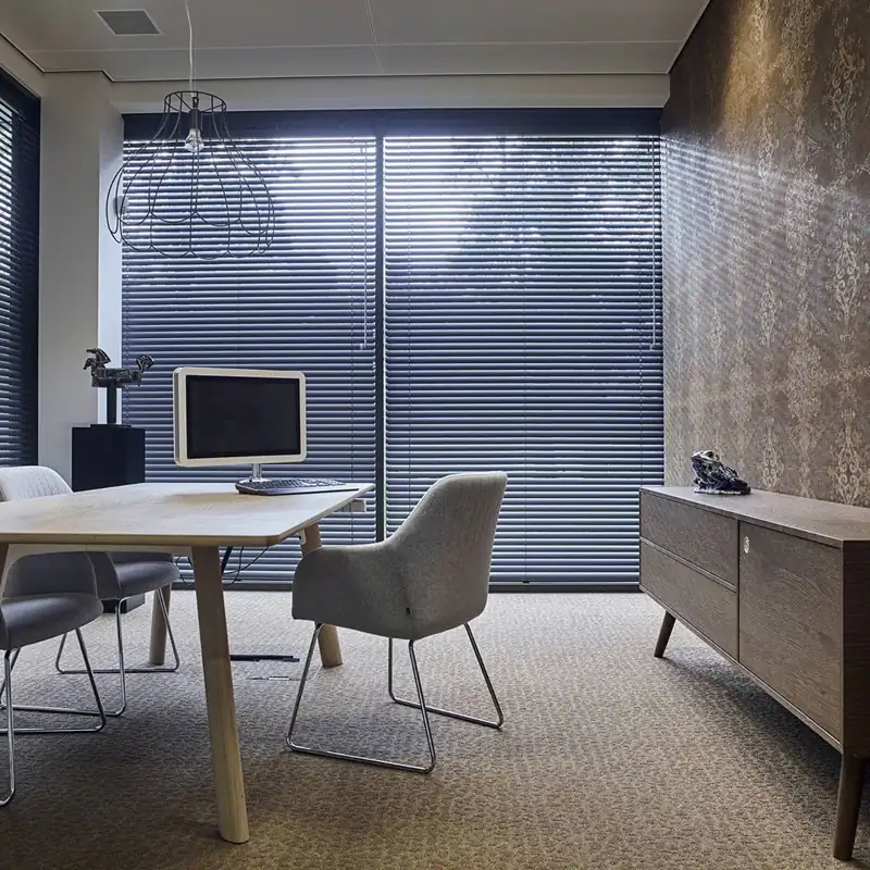 Horizontal charcoal venetian blinds in a stylish home office.