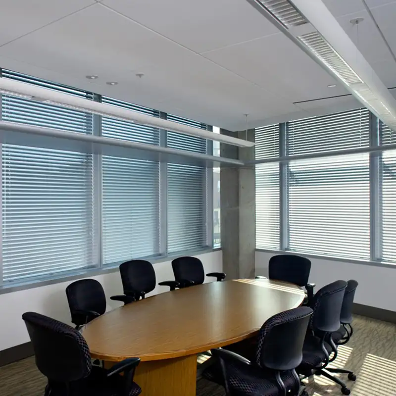 Silver venetian blinds in a corporate conference room.