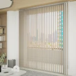 Vertical blinds covering a large glass window in a room.