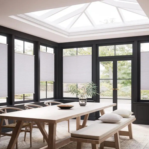White pleated blinds in a bright, modern dining room.