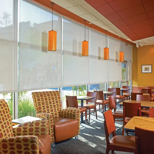 white solar roller blinds installed in a vibrant corporate cafeteria